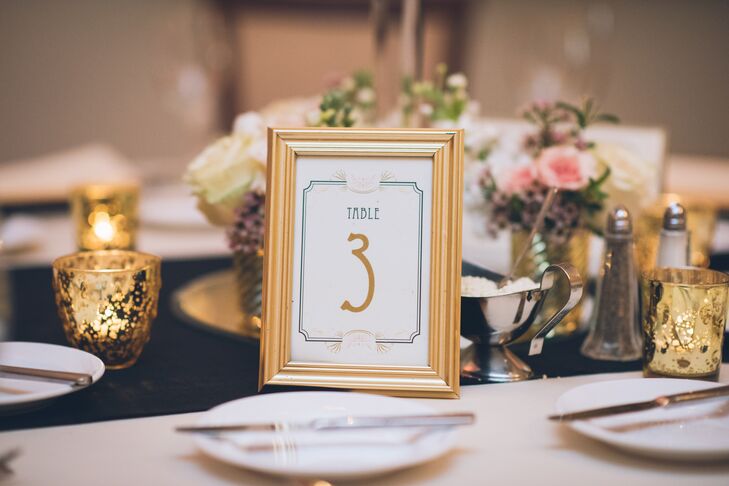 Designed by Beacon Lane, each table captured the couple’s “Old Hollywood” inspiration with a chic design. A geometric navy border circled encased each gold numeral. The surrounding gold frames highlighted every place setting with coordinating gold chargers and matching votive candles.