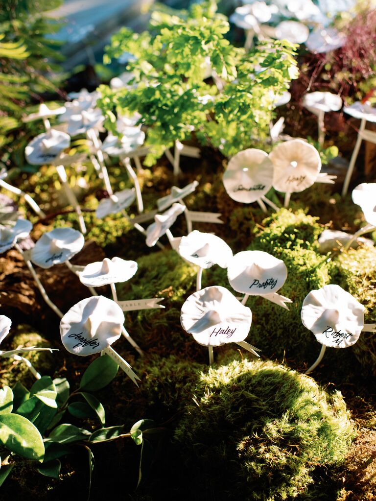 2023 wedding flower trend mushroom escort card display with guest names written onto white mushrooms