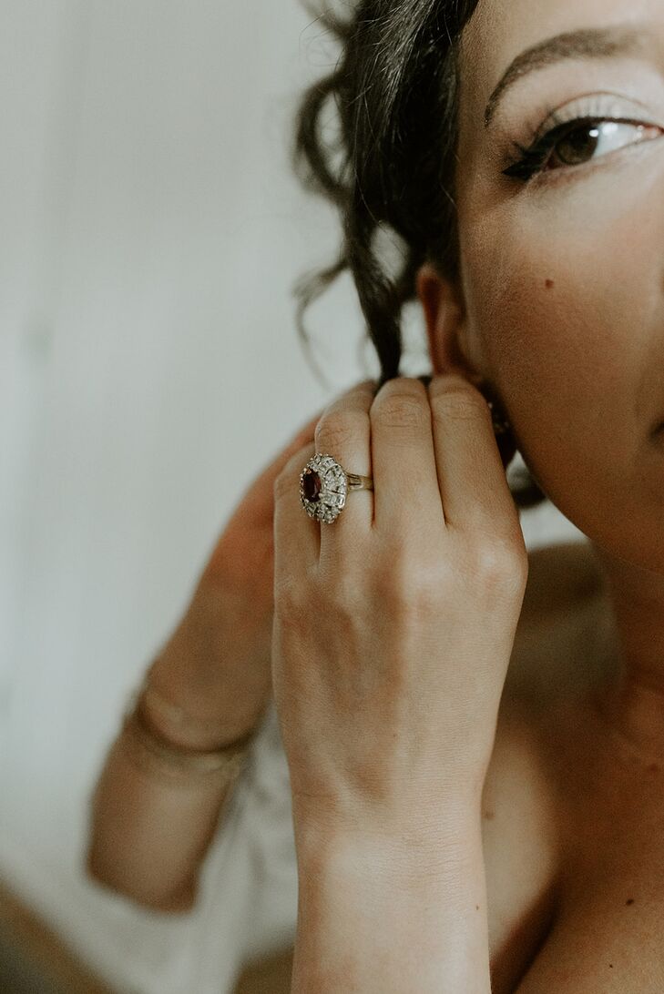 Bride Wearing Vintage Engagement Ring Putting on Earrings