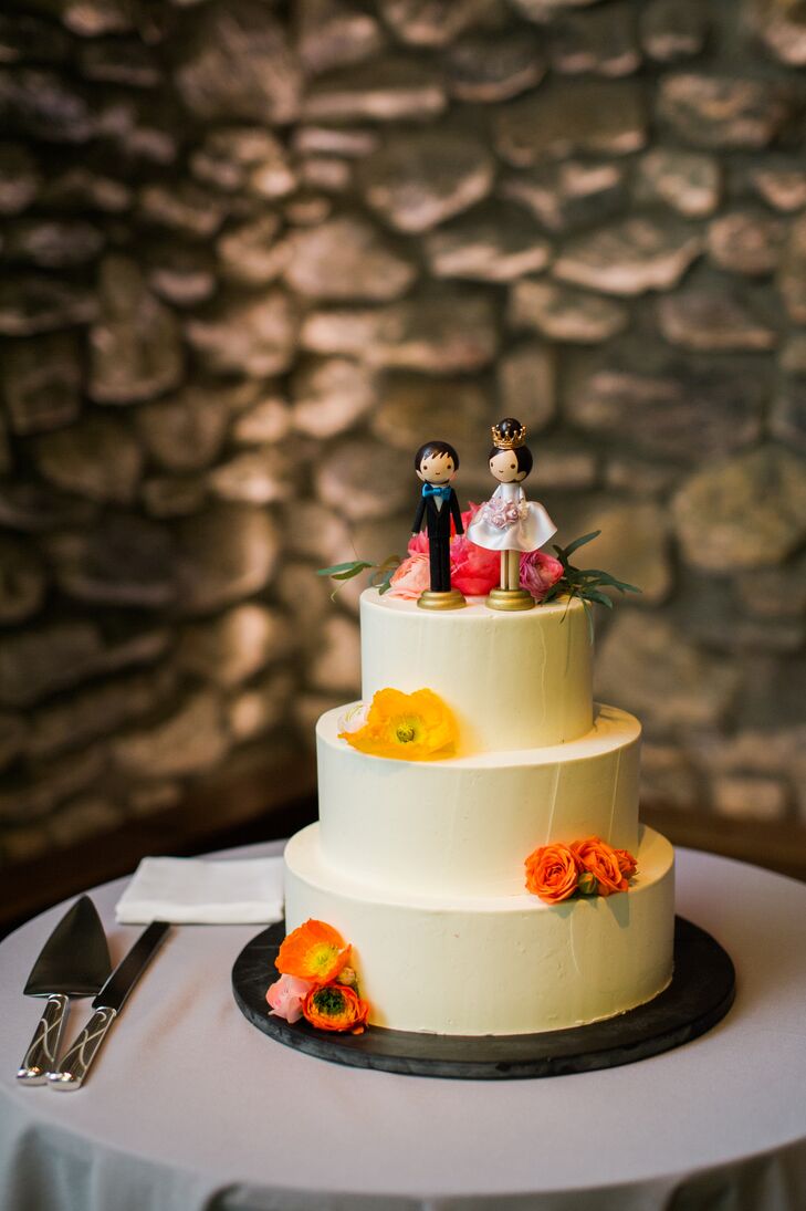 After dinner, Alice and Stephen treated guests to three flavors of wedding cake, such as chocolate cake with chocolate mousse, vanilla cake with raspberry preserves and almond cake with poached pears and caramel mousse. Ivory buttercream adorned each layer, carefully frosted to create a blank canvas for radiant yellow, orange and pink flowers and a playful wooden bride and groom cake topper.