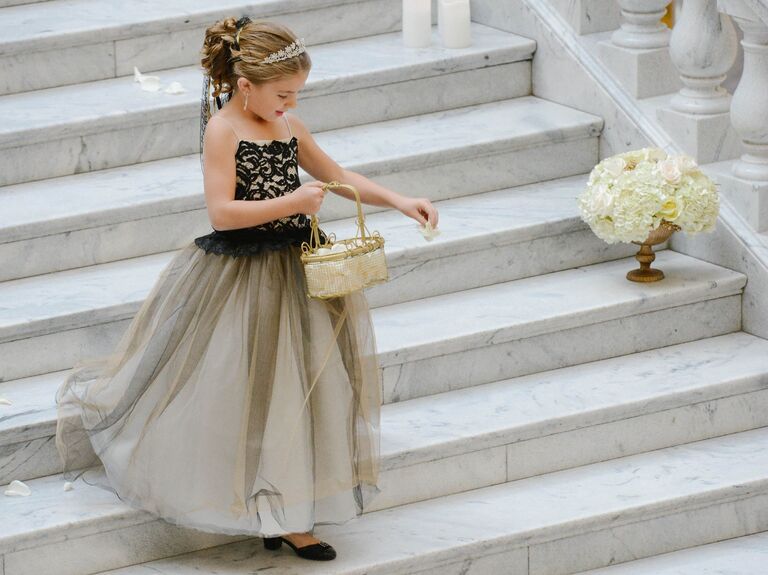 Flower girl wears her hair in an elegant updo with a sparkling tiara. 