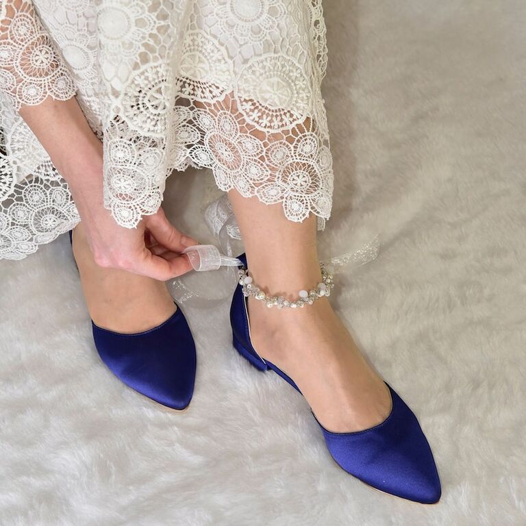 Model wearing a rich navy pump with a pearl and crytsal ankle strap
