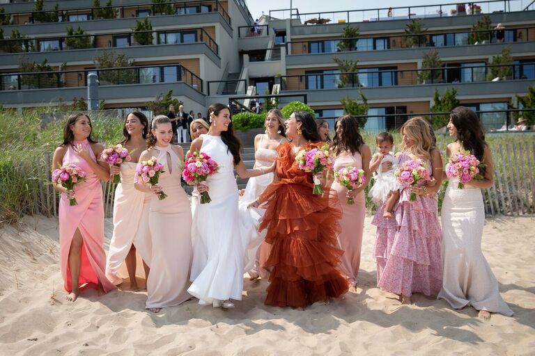 Bridal party wearing various dresses in pink and red shades
