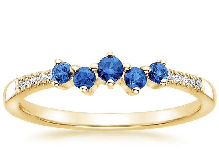 Gold ring with five round blue sapphires and pave diamonds on band