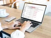 Wedding planning spreadsheet on a laptop and mobile device.
