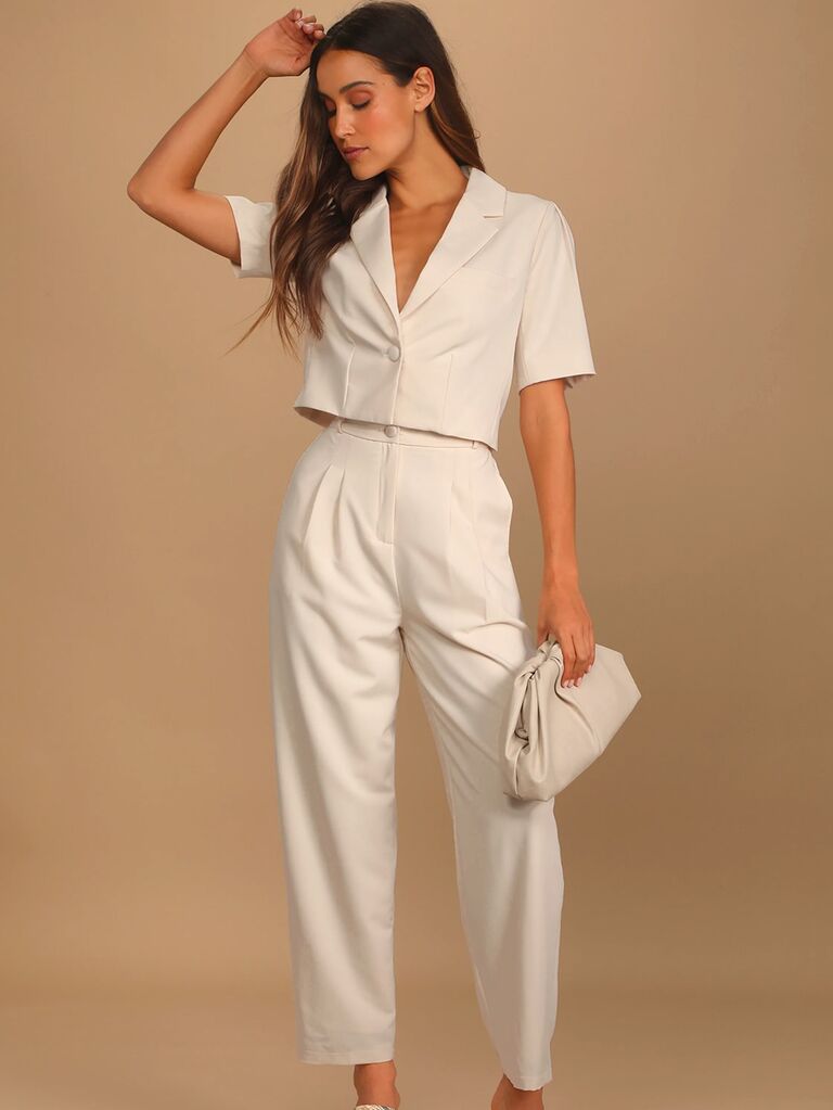Model wears a short sleeved white suit set. 