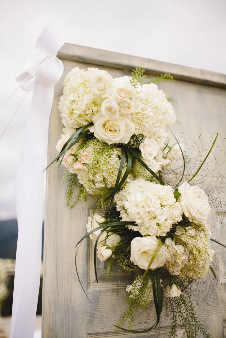 Clusters of white roses and hydrangeas decorated the ceremony site.