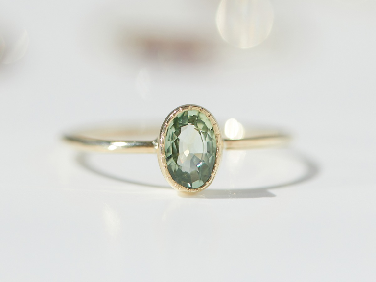 An oval-shaped greenish sapphire.
