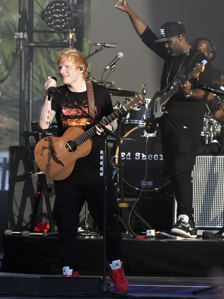 Ed Sheeran playing the guitar outside at his concert