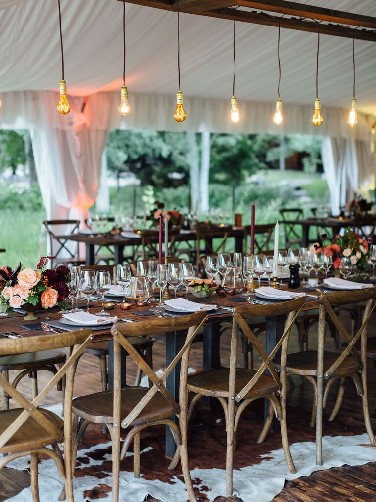 long wedding reception table with a row of edison bulb lights hanging above
