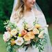 Bride With Bouquet of Zinnias, Ranunculus, Roses, Yarrow, Oranges and Grapefruit
