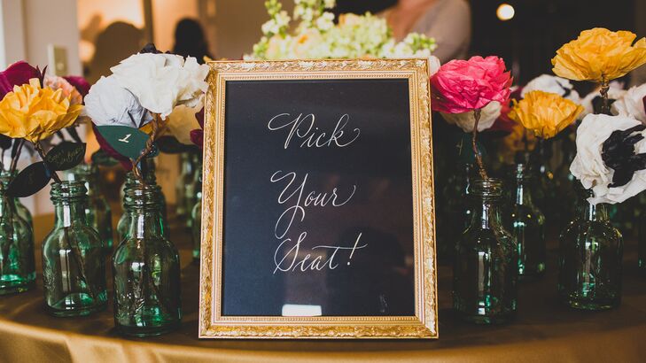 The escort cards were attached to colorful paper flowers in glass vases.