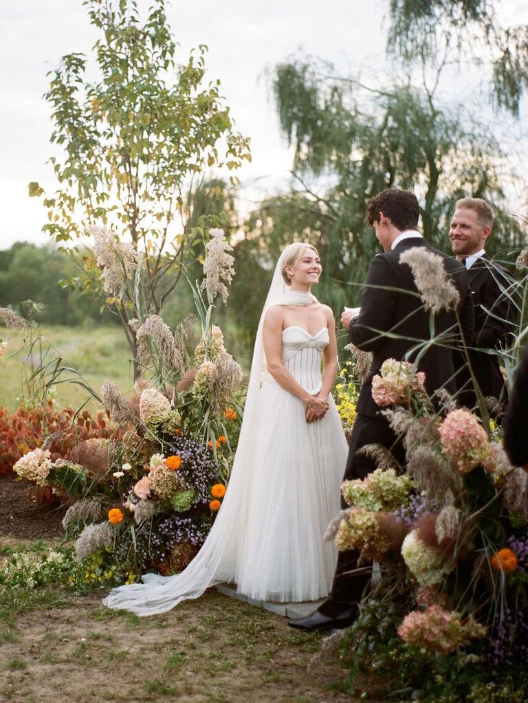 AnnaSophia Robb smiles at her partner during her outdoor wedding ceremony. 