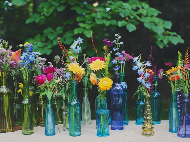 Multicolor wedding reception vases with flowers outdoors