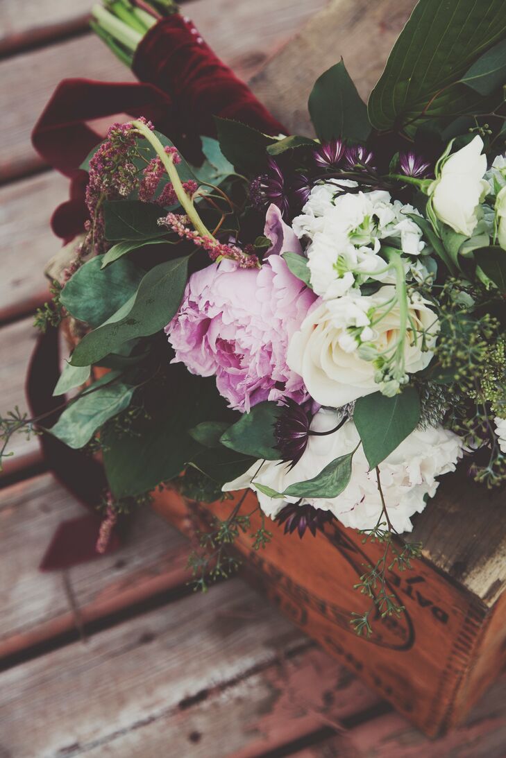 Justine carried a bouquet with pink and white peonies, white roses, white stock flowers and greens. her bouquet was wrapped with burgundy velvet ribbon.