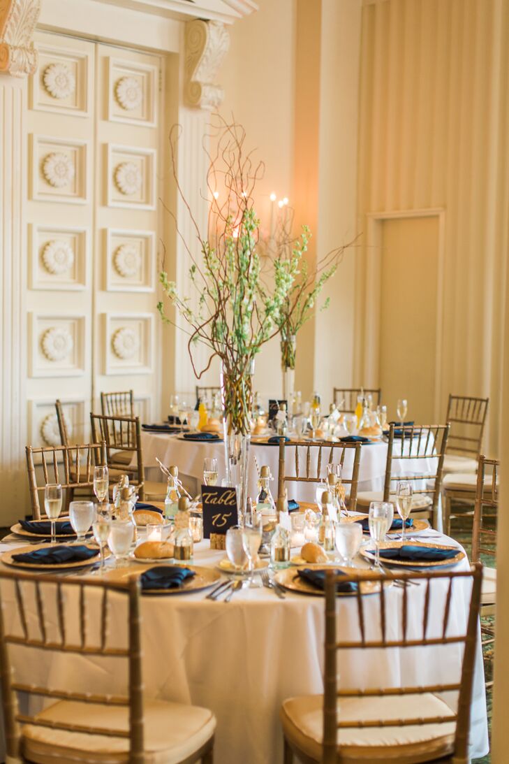 While the rest of their decor was gold, ivory or navy, Brianna and Eric went for a natural look with tall centerpieces. Jim Ludwig’s Blumengarten Florist designed each one with curly willow-tip branches and white larkspur that burst from a clear glass trumpet vase.