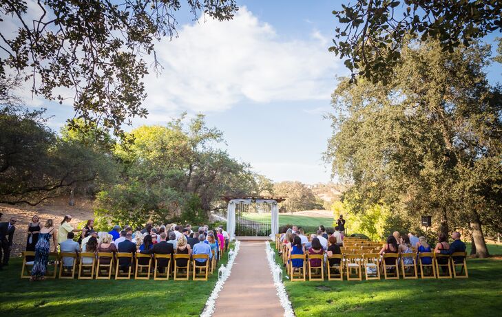 The ceremony took place on the lawn outside at Catta Verdera Country Club in Lincoln, California. The aisle was lined with white petals and lanterns, which led to the wedding arch that was draped in strings of crystals and white linens.
