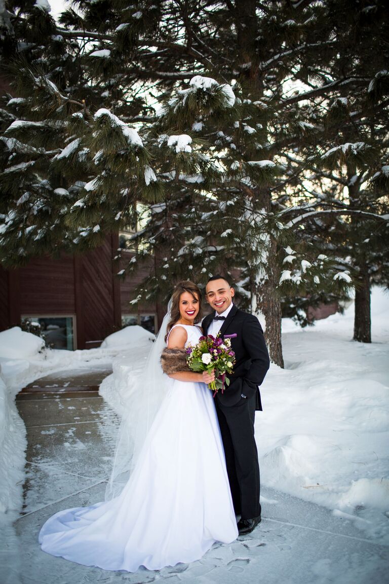 bride and groom posing in the snow