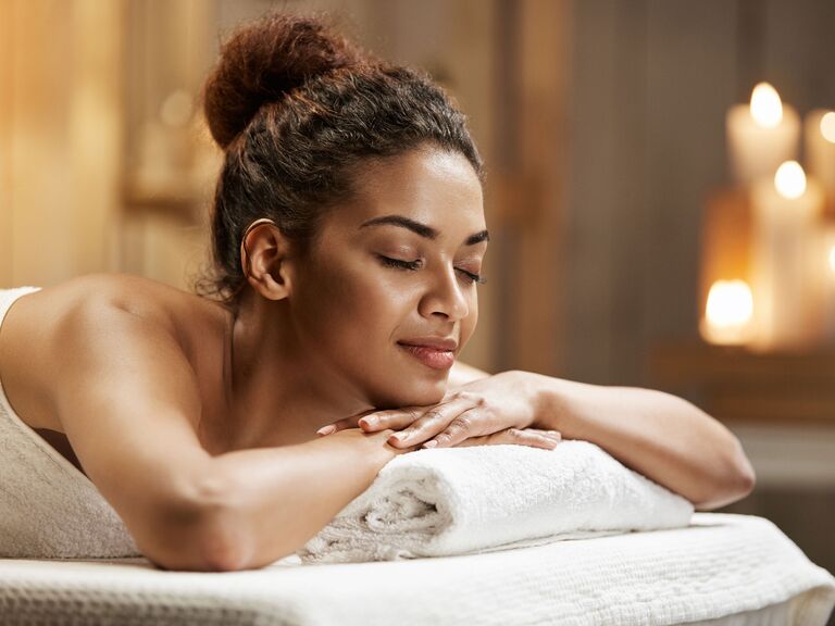 Woman relaxing on massage table spa voucher bridesmaid gift idea