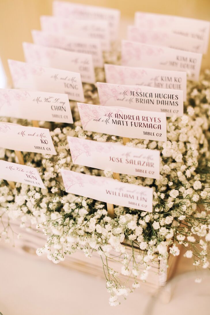 The escort cards were placed in wooden boxes peeking out of an arrangement of dainty white florals.