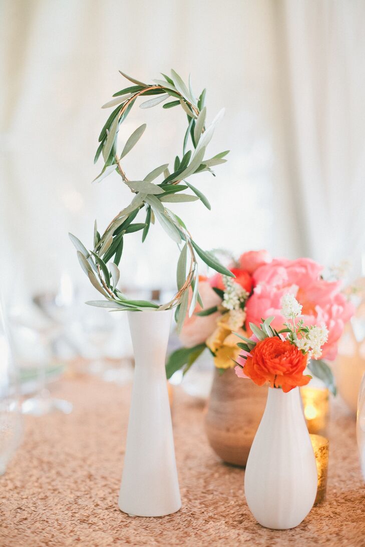 To make the table numbers, JL Designs wrapped olive branches around wire in the shape of each number and then placed them in white ceramic vases.