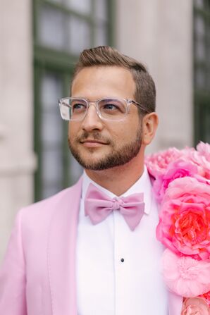 Groom in Pink Tuxedo Jacket, Pink Bow Tie and Bold Silk Floral Lapel Accessory