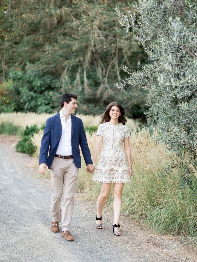 couple walking in park during spring engagement photo shoot
