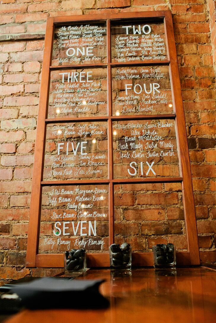 The bride and groom painted their guest's seating assignments on a repurposed window.