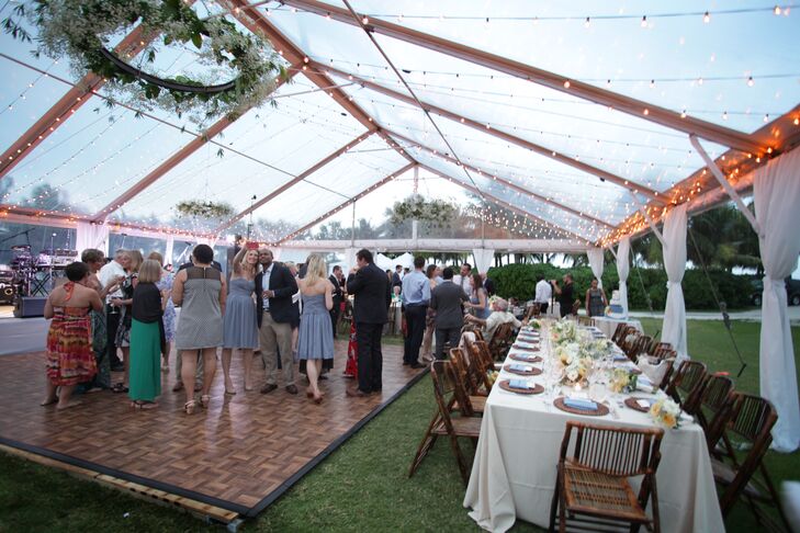 The couple decorated their reception with round and family-style tables, rattan chargers, neutral linens, French blue napkins, floral centerpieces, bamboo chairs and grapevine wood accents.