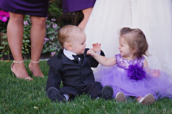 The flower girl wore a tutu-style purple tulle dress. The bodice was accented with sequins to match the sparkly theme of the wedding. She also wore a plum tulle flower around her waist to match the bridesmaids' dresses. The ring bearer wore a classic three-piece black suit complete with a black bow tie.