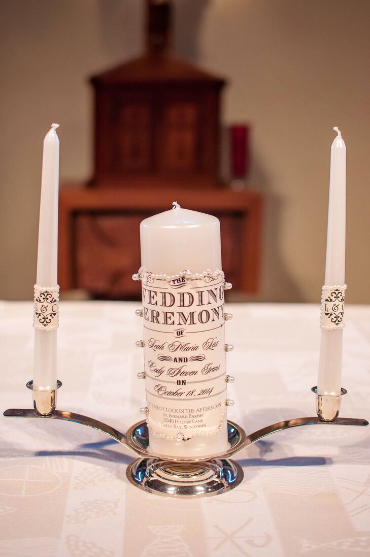 For their unity ceremony, Leah and Cody lit a large candle with two monogrammed taper candles. They held a traditional Catholic ceremony at St. Bernard because they wanted a church venue that they would be able to return to week after week.