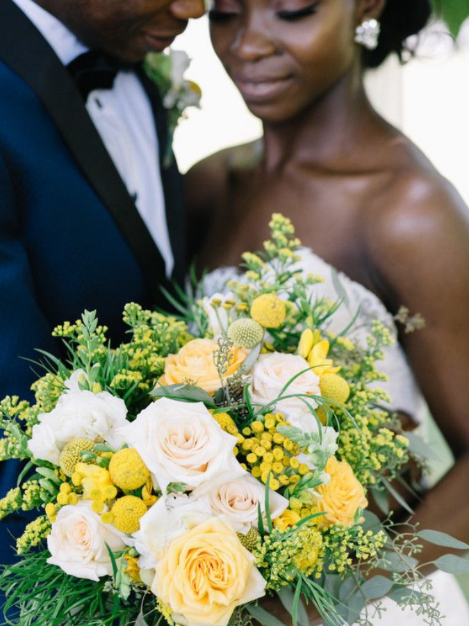 Bride holding yellow-and-white bouquet 