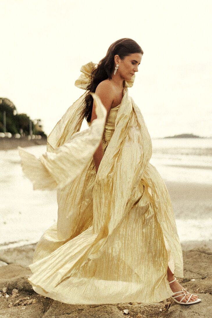 Bride in Flowing Gold Metallic Gown and Down Hairstyle on Rocky Beach