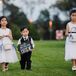 The flower girls wore white dresses and carried white baskets filled with rose petals while John's nephew carried a chalkboard sign that said "Here Comes Your Bride."