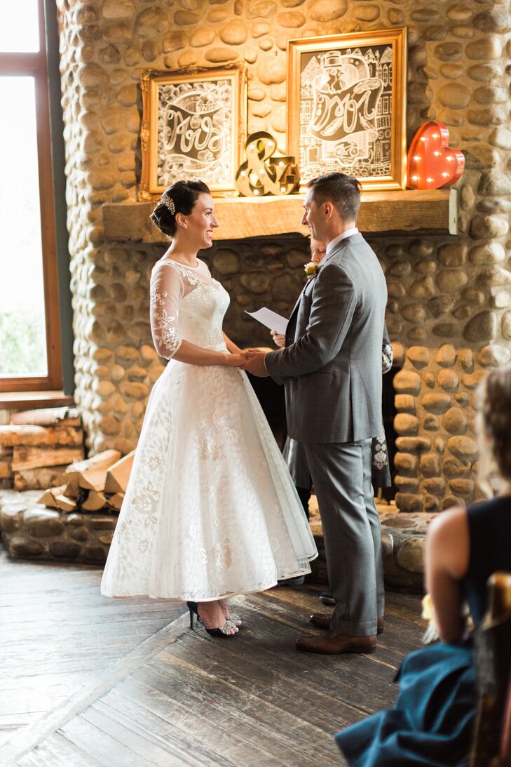 Jennifer and Jason got married at their favorite spot to bike and eat, the River Cafe in Calgary, Alberta. Their ceremony was supposed to take place outside, but they moved indoors and exchanged vows in front of the stone fireplace instead. (Rain on the wedding day is supposed to be good luck, after all.) As an added DIY touch, Jennifer drew the "Mrs." and "Mr." chalkboard art on the mantel, placed beside retro marquee symbols.