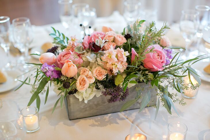 Twisted Willow Florist created centerpieces that featured flower boxes filled with blush, pink and purple blooms and votive candles.