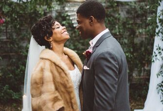 Bride wearing faux fur coverup at winter wedding with groom