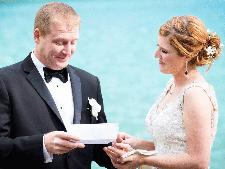 Groom reading handwritten private vows from bride. 