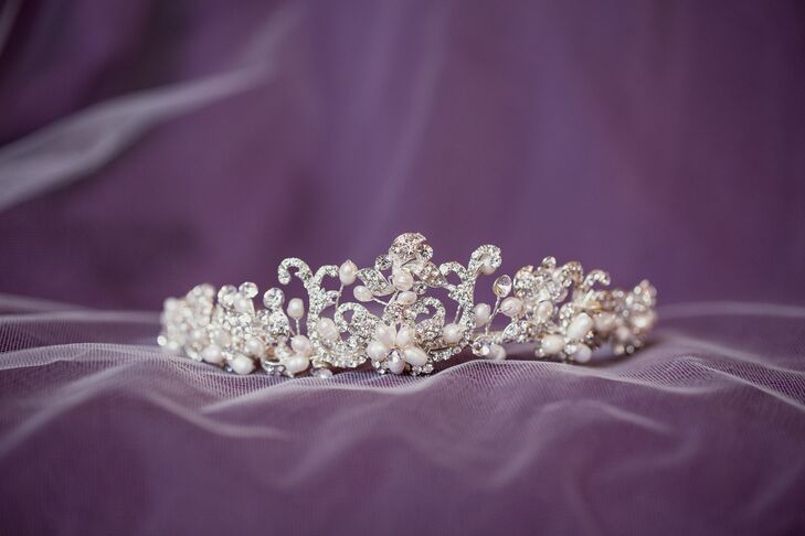 Sarah complemented her A-line wedding dress with a few classic touches. She paired her curled down hairstyle with a floor-length vintage veil during the ceremony, as well as a fun headpiece. She wore a crystal and pearl tiara with a floral design that complemented the embroidery on her wedding dress.