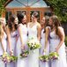 Bridesmaids wore floor-length flowing lilac gowns and carried bouquets with pops of purple blooms.