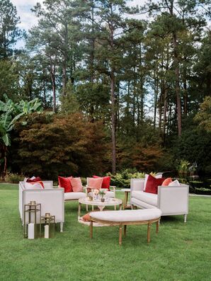 Garden Lounge Space With Red and Blush Pillows, Couches and Coffee Table