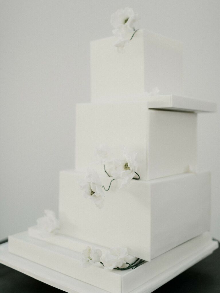 modern minimalist wedding cake with asymmetrical square tiers and white flowers