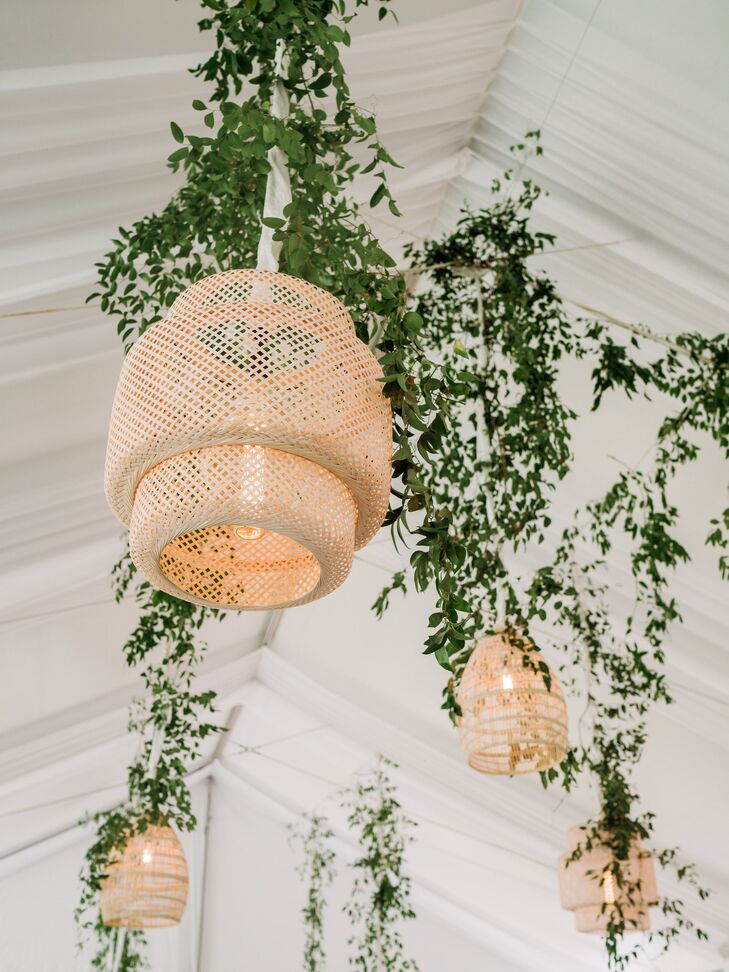 Rattan Chandeliers With Ivy Greenery Hanging From Tent Ceiling at Reception