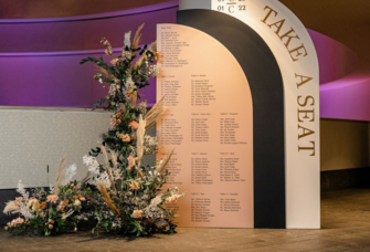 Large arch seating chart display with flower arrangement