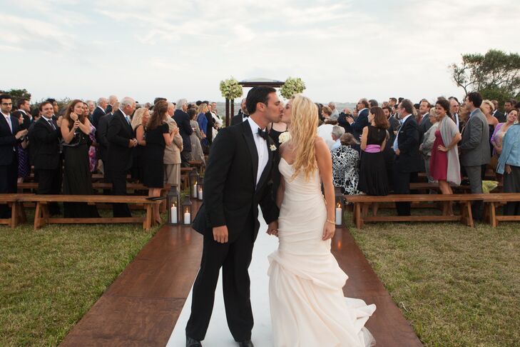 Nora wore a simple, mermaid-style Monique L'huillier gown in blush silk Jacquard. All of the jewelrey that she wore on her wedding day was designed by her mother, which included an 18K matte gold and diamond wave bracelet, a matte gold triple-ridge ring with cabochon moonstone and a matte gold and diamond woven earrings.