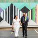 Modern Couple Wearing White Jumpsuit, Black Suit and Colorful Scarf