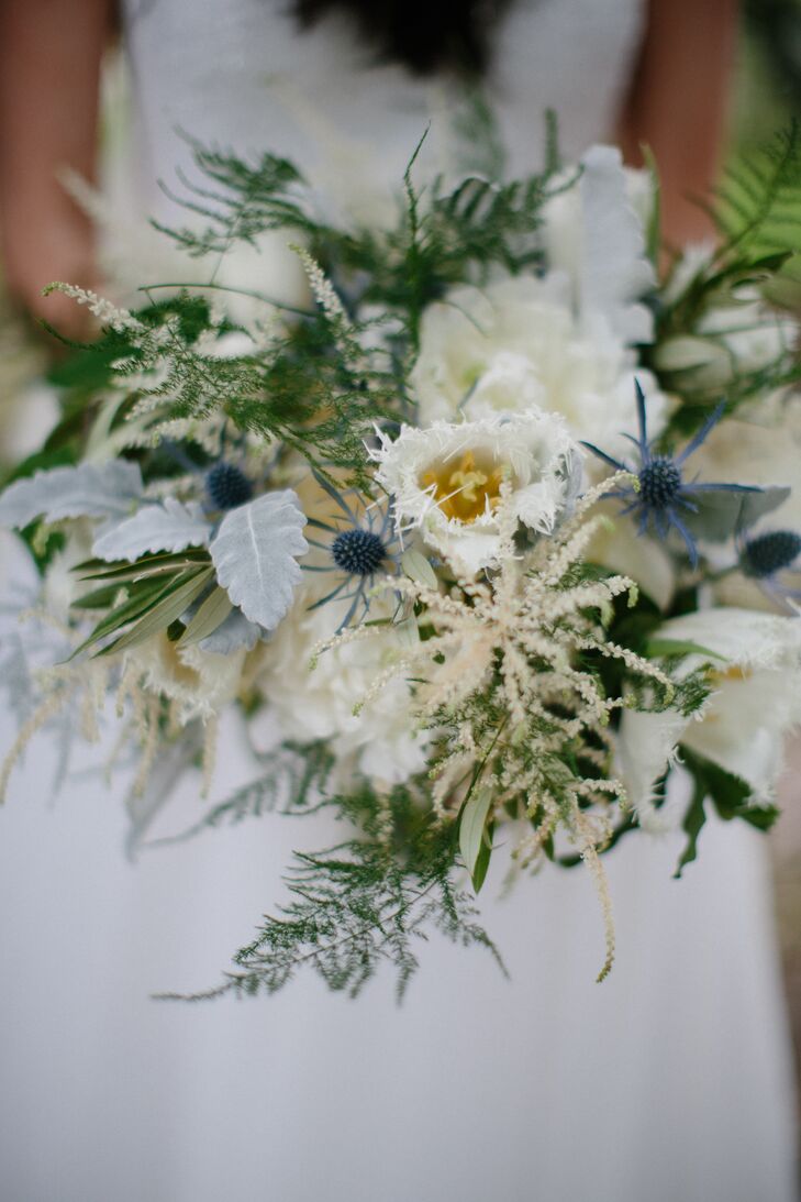 Nina carried white peonies, blue thistle, dusty miller, olive branches, white tulips, green plumosa, white astilbes, jasmine vines and white garden roses hand-tied with an ivory ribbon down the aisle. She and Tristan loved incorporating thistles (Scotland's national flower) into the textured florals to represent his heritage.