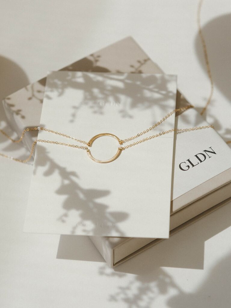Dainty gold friendship necklaces that each depict half of a circle. 