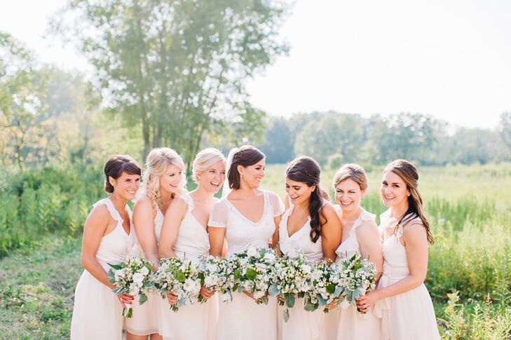 Anna chose ivory Joanna August dresses for each of her bridesmaids thanks to the casual design of each. "Since the venue was outside, I wanted the girls to be comfortable," she says. The group completed their wedding day style with gold initial charm necklaces gifted to them by the bride.