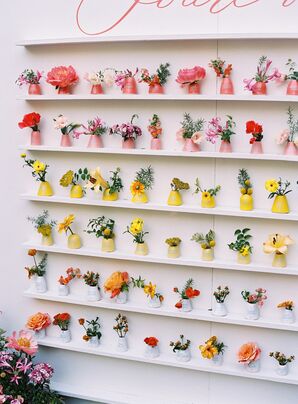 Colorful Escort Card Display With Live Flowers and Personalized Vases